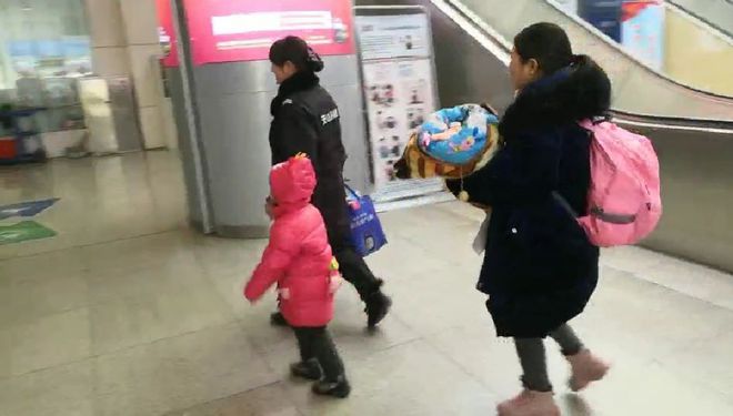母亲独自带俩娃赶火车 路人伸出援手
